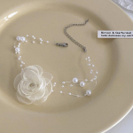 Romanti&scaron;kas perlų kaklo papuo&scaron;alas su kamelijomis, juodai baltas, vasarinis raktikaulio grandinėlės formos pakabukas