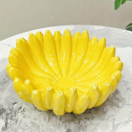 1 vnt. Eleganti&scaron;kas banano formos keraminis vaisių dubuo, ry&scaron;kiai geltonos spalvos blizgus pavir&scaron;ius, žiedlapių formos dizainas, patvarus, saugus maistui, namų dekoras arba vie&scaron;bučių restoranams 1pc