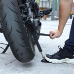 Universalus motociklo ratų stovas su taupantį jėgas atraminiu kojeliu, &scaron;vytuoklės svirties keltuvo rėmas padangų priežiūrai, &scaron;oninė atrama daugumai motociklų juoda