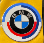 BMW MOTORSPORT 50 METŲ BAGAŽINĖS DANGČIO EMBLEMA 74 MM SKERSMENS 51148087195 ORIGINALI